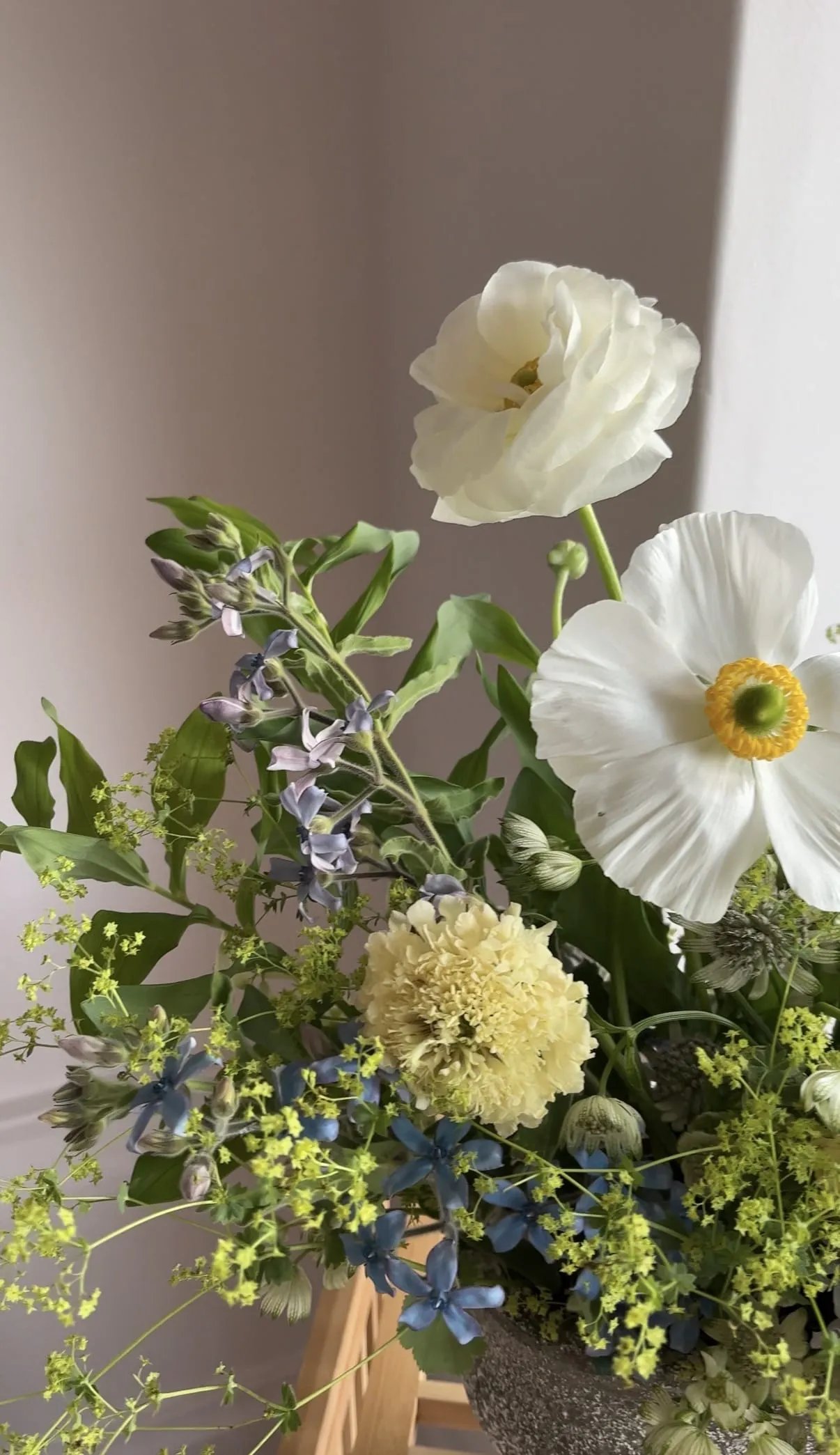 Airy pink bouquet arranged in a glass vessel with sweet peas and blush blooms.