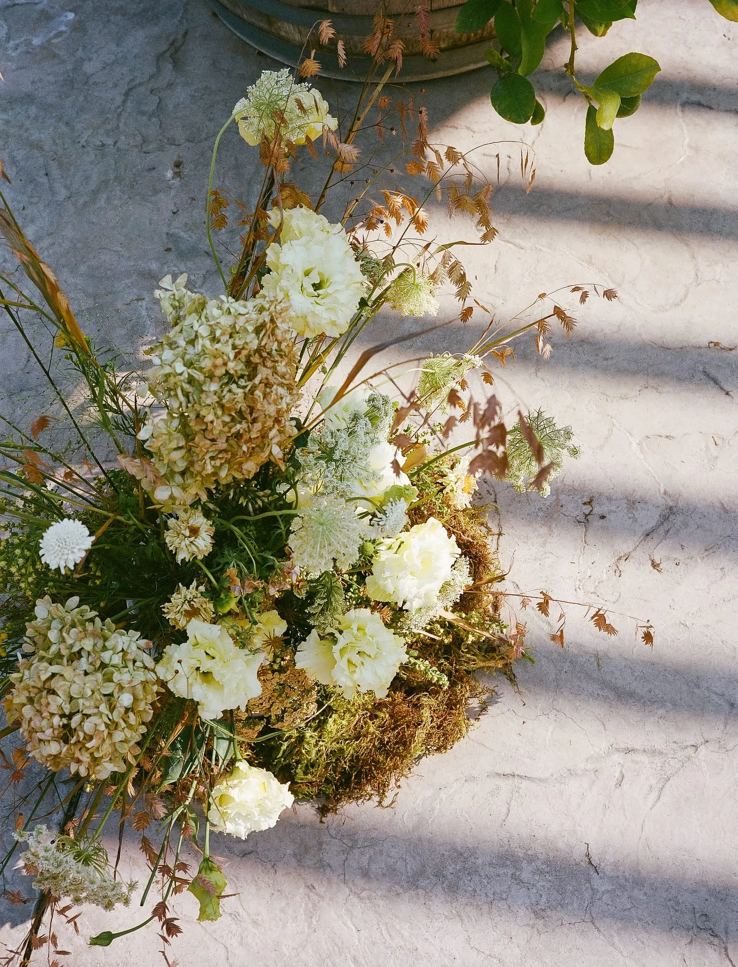 Wedding table floral arrangement with textured petals in pink and ivory tones.