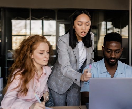 Group of people discussing something shwon on a laptop